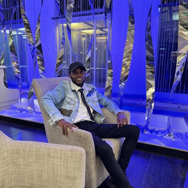 Godwill Barasa seated in an armchair in a blue-lit interior in Nairobi